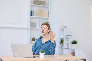 Photo of Air conditioning. Woman suffering from heat at workplace in office