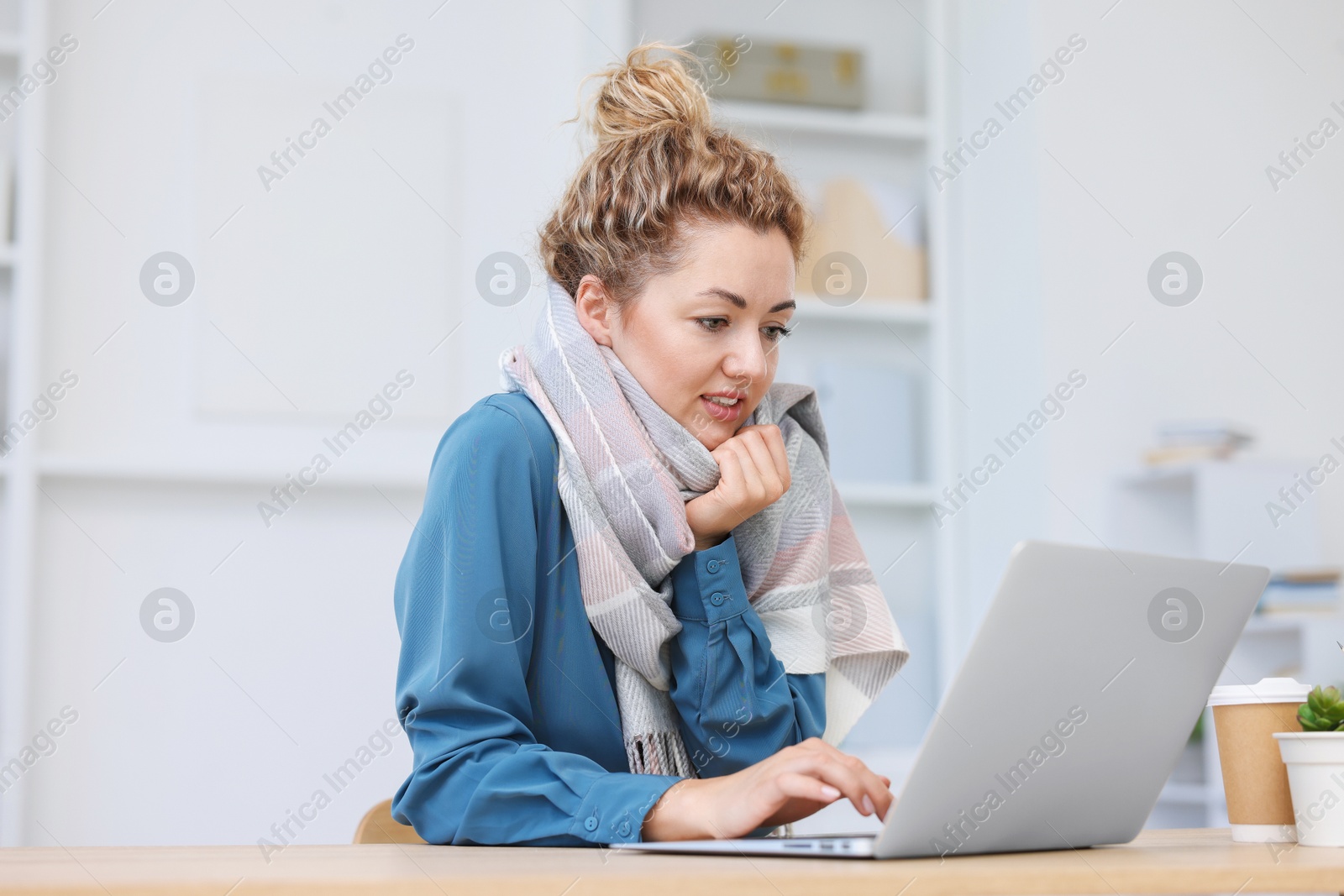 Air conditioning. Woman with scarf suffering from cold temperature at workplace in office Photo of Air conditioning. Woman with scarf suffering from cold temperature at workplace in office