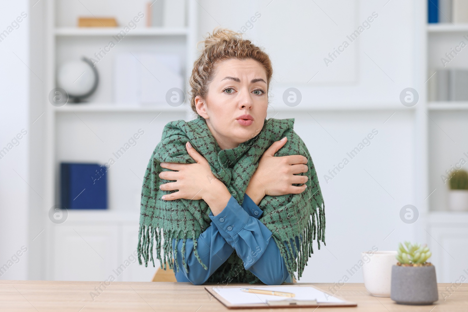 Air conditioning. Woman with scarf suffering from cold temperature at workplace in office Photo of Air conditioning. Woman with scarf suffering from cold temperature at workplace in office