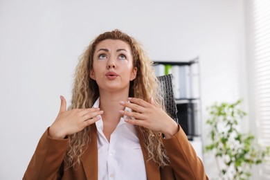 Photo of Air conditioning. Woman suffering from heat at workplace in office