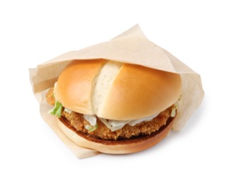 Photo of One delicious burger with lettuce and deep fried patty in takeaway package isolated on white. Tasty fast food