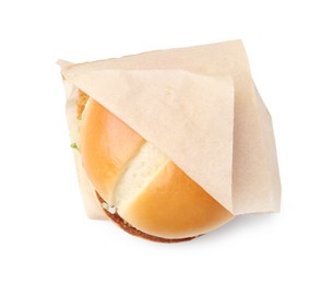 Photo of One delicious burger in takeaway package isolated on white, top view. Tasty fast food