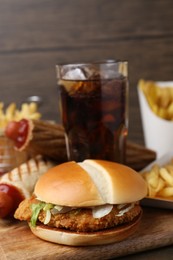 Photo of Delicious burger, cola and other fast food on table, closeup