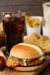 Photo of Delicious burger, cola and other fast food on table, closeup