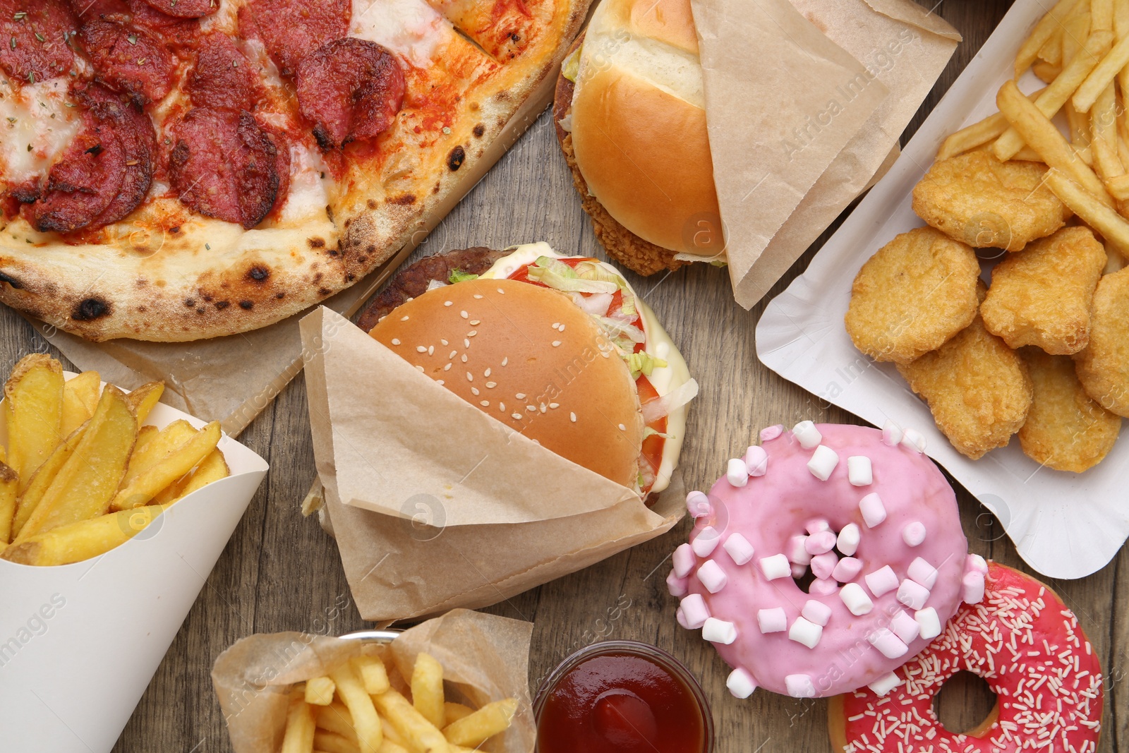 Different delicious fast food on wooden table, flat lay Photo of Different delicious fast food on wooden table, flat lay