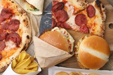 Photo of Different delicious fast food and cola on wooden table, flat lay