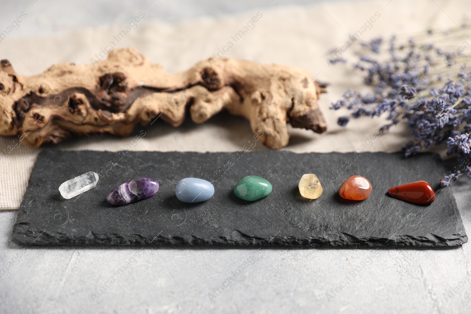 Chakra gemstones and lavender flowers on light table, closeup Photo of Chakra gemstones and lavender flowers on light table, closeup