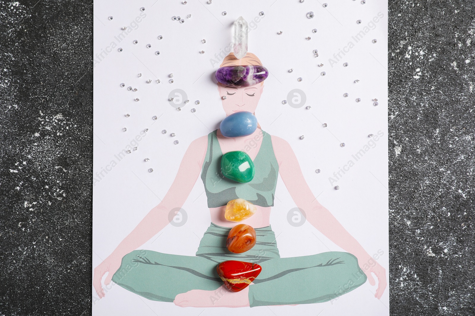 Human drawing with gemstones placed on chakras against black background, top view Photo of Human drawing with gemstones placed on chakras against black background, top view