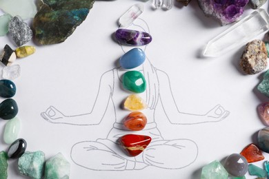 Photo of Human drawing with gemstones placed on chakras, flat lay