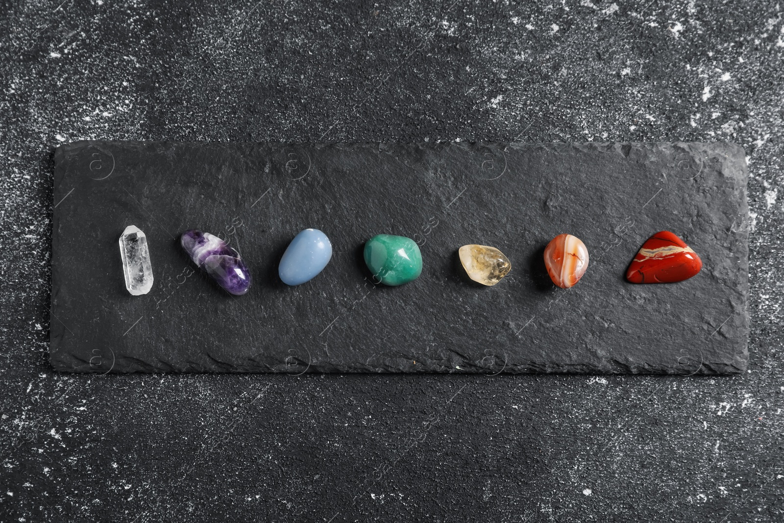 Chakra gemstones on black table, top view Photo of Chakra gemstones on black table, top view