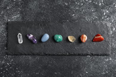 Photo of Chakra gemstones on black table, top view