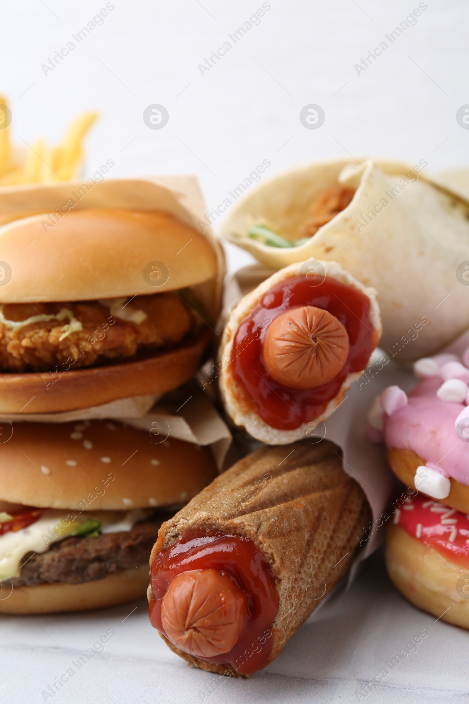 Different delicious fast food on white table, closeup Photo of Different delicious fast food on white table, closeup
