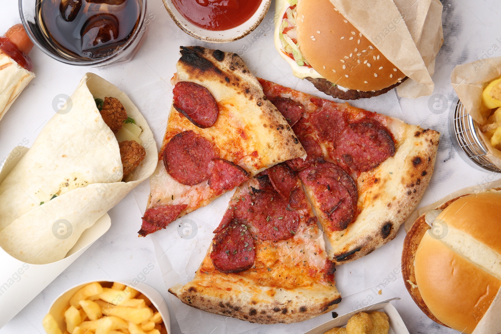 Different delicious fast food and soda drink on white marble table, flat lay Photo of Different delicious fast food and soda drink on white marble table, flat lay