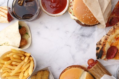 Photo of Different delicious fast food and soda drink on white marble table, flat lay. Space for text