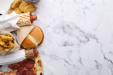 Photo of Different delicious fast food on white marble table, flat lay. Space for text