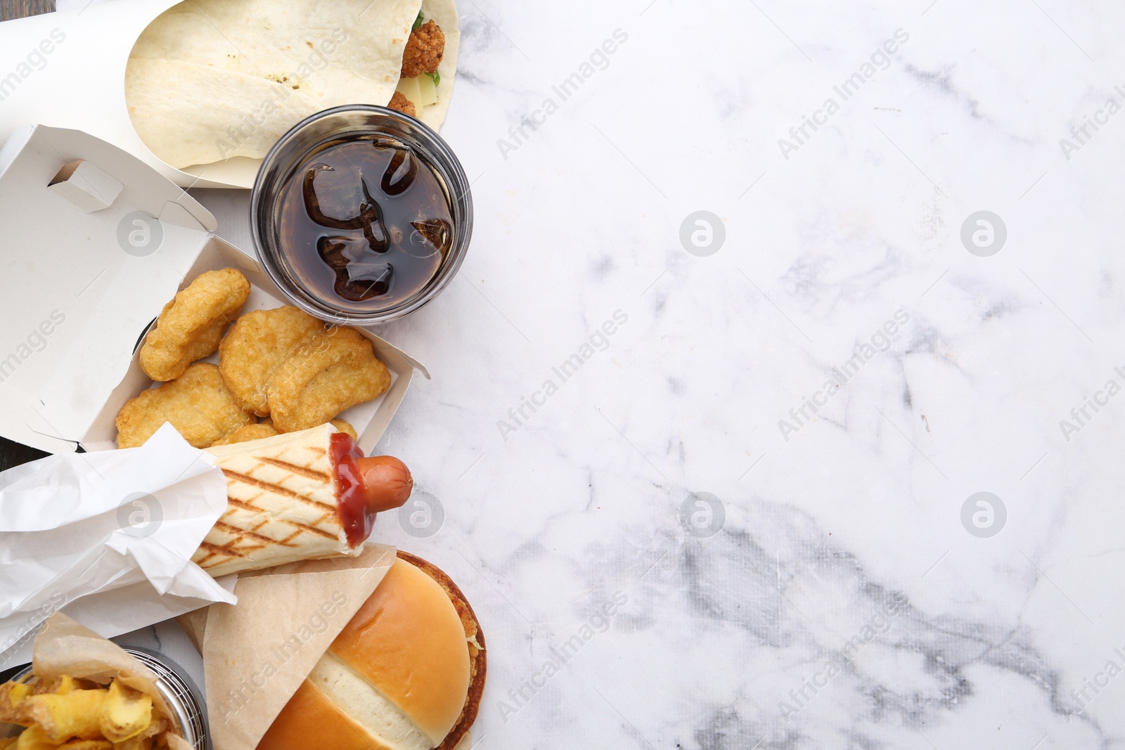 Different delicious fast food and soda drink on white marble table, flat lay. Space for text Photo of Different delicious fast food and soda drink on white marble table, flat lay. Space for text
