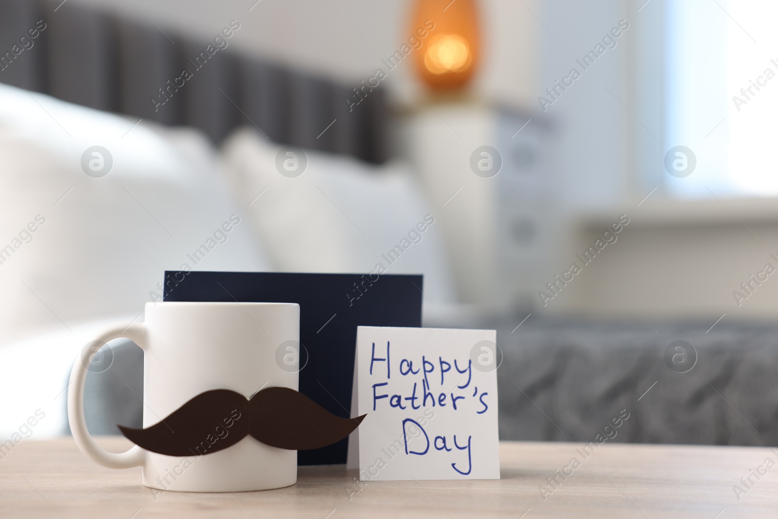 Happy Father's Day card, cup with mustache and envelope on wooden table at home, closeup Photo of Happy Father's Day card, cup with mustache and envelope on wooden table at home, closeup