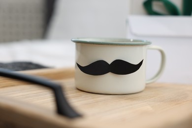 Photo of Happy Father's Day. Cup with mustache on bed at home, closeup