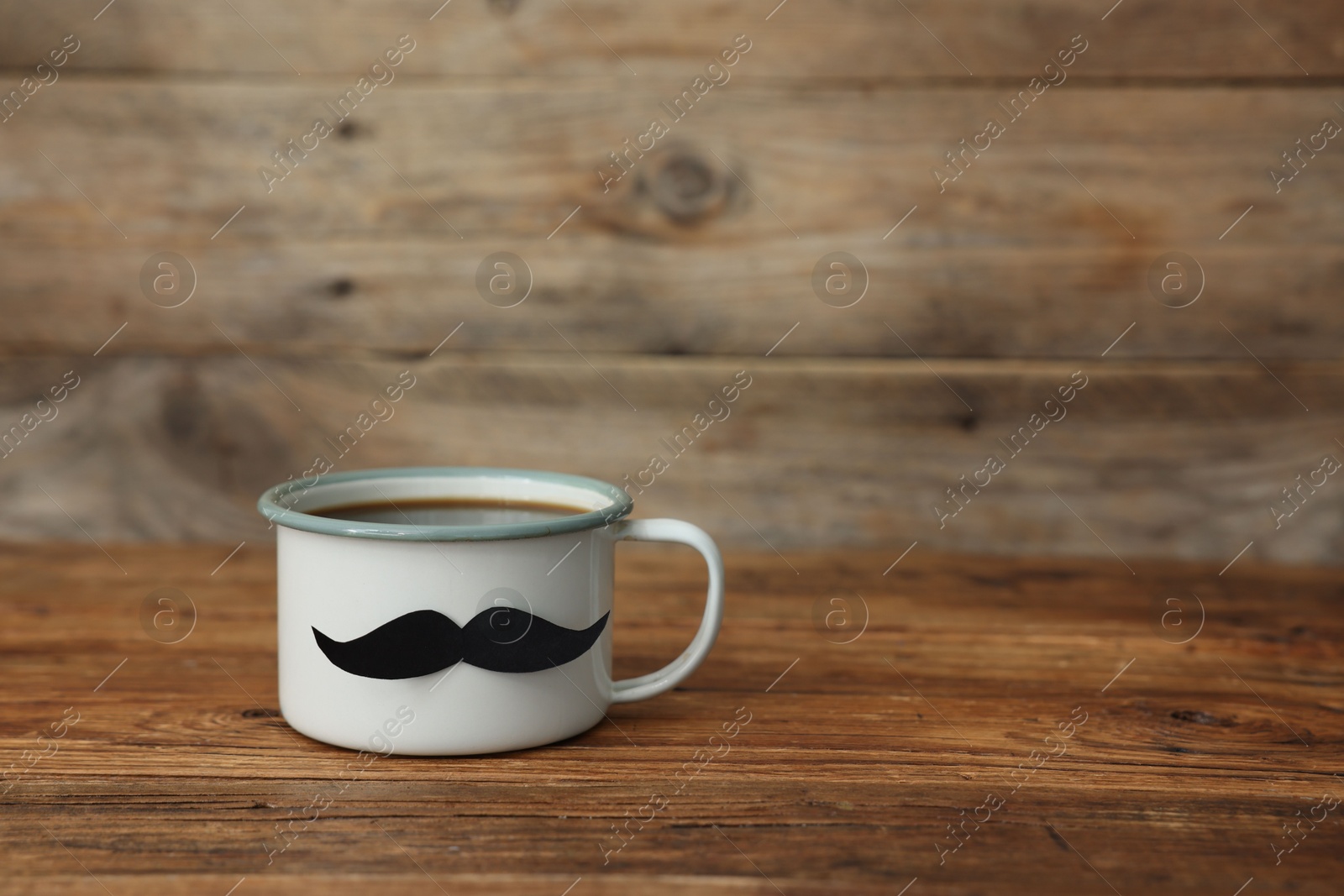 Happy Father's Day. Cup with mustache on wooden table. Space for text Photo of Happy Father's Day. Cup with mustache on wooden table. Space for text