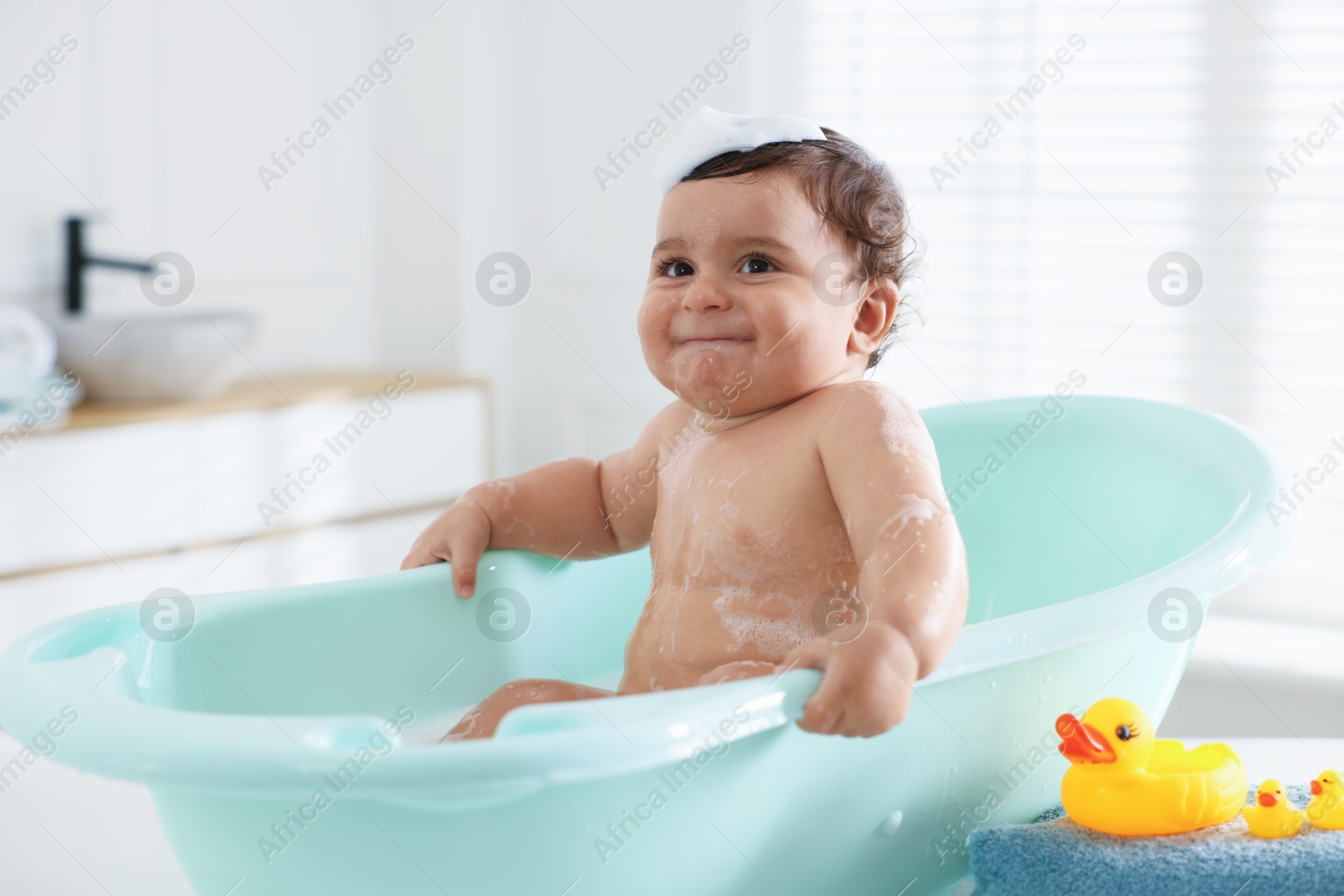 Cute little baby bathing in tub at home Photo of Cute little baby bathing in tub at home