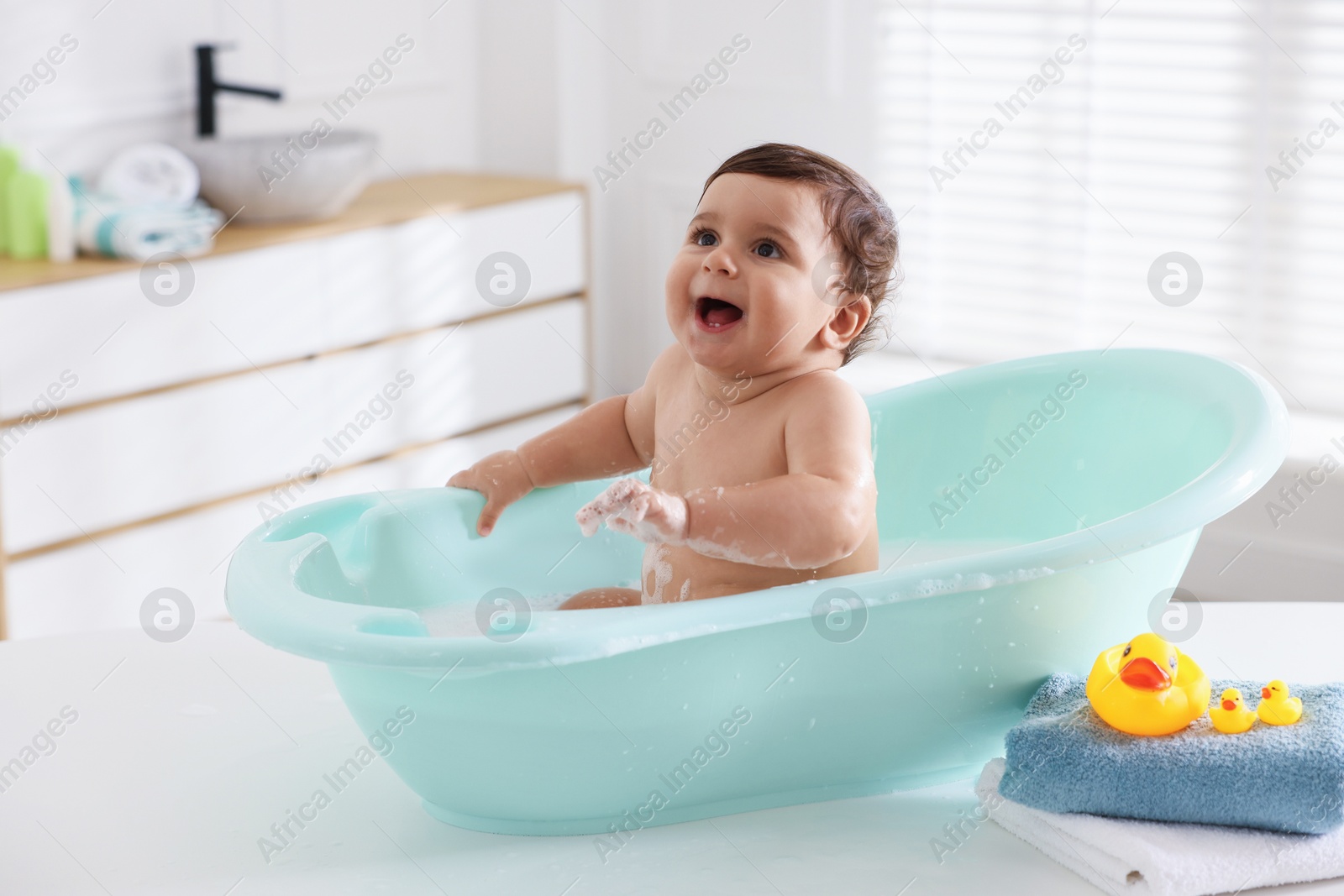 Cute little baby bathing in tub at home Photo of Cute little baby bathing in tub at home