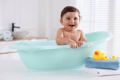 Photo of Cute little baby bathing in tub at home