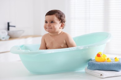 Photo of Cute little baby bathing in tub at home
