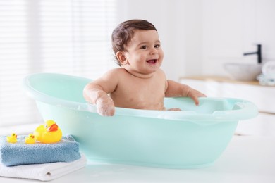 Photo of Cute little baby bathing in tub at home