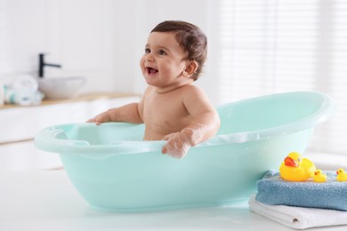 Photo of Cute little baby bathing in tub at home