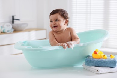 Photo of Cute little baby bathing in tub at home