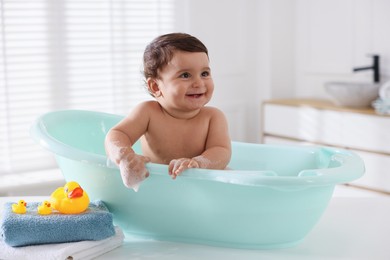 Photo of Cute little baby bathing in tub at home