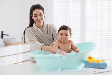 Photo of Mom bathing her cute little baby at home
