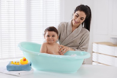 Photo of Mom bathing her cute little baby at home