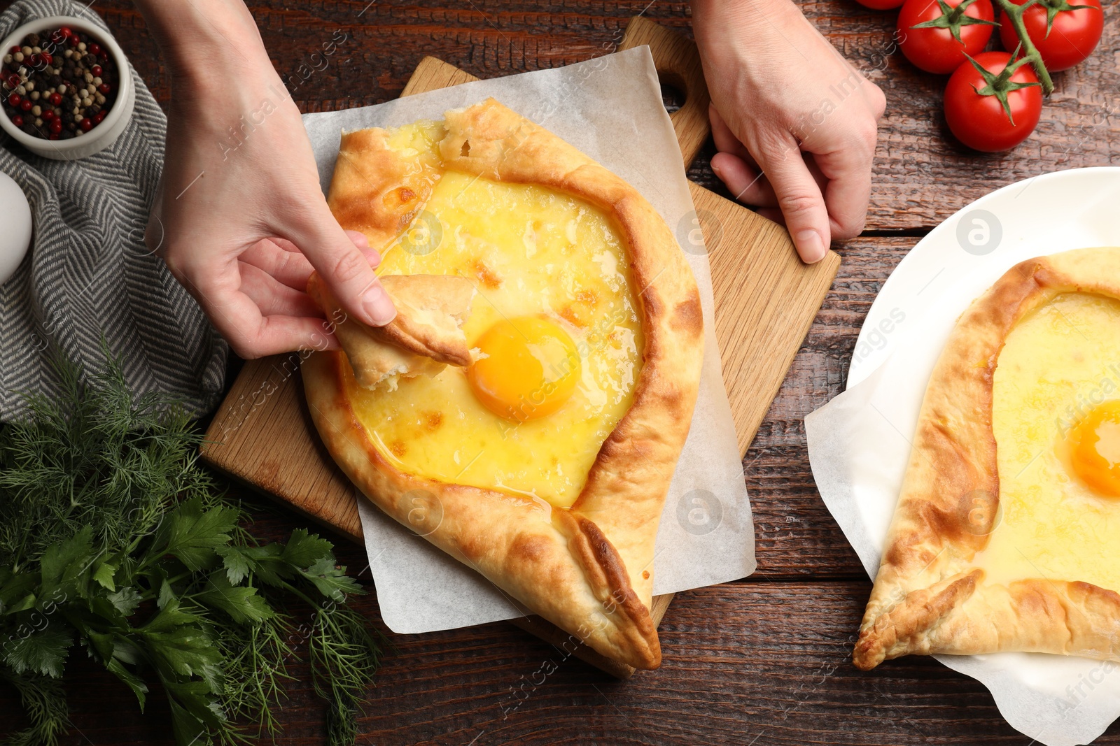 Woman eating delicious khachapuri at wooden table, top view Photo of Woman eating delicious khachapuri at wooden table, top view