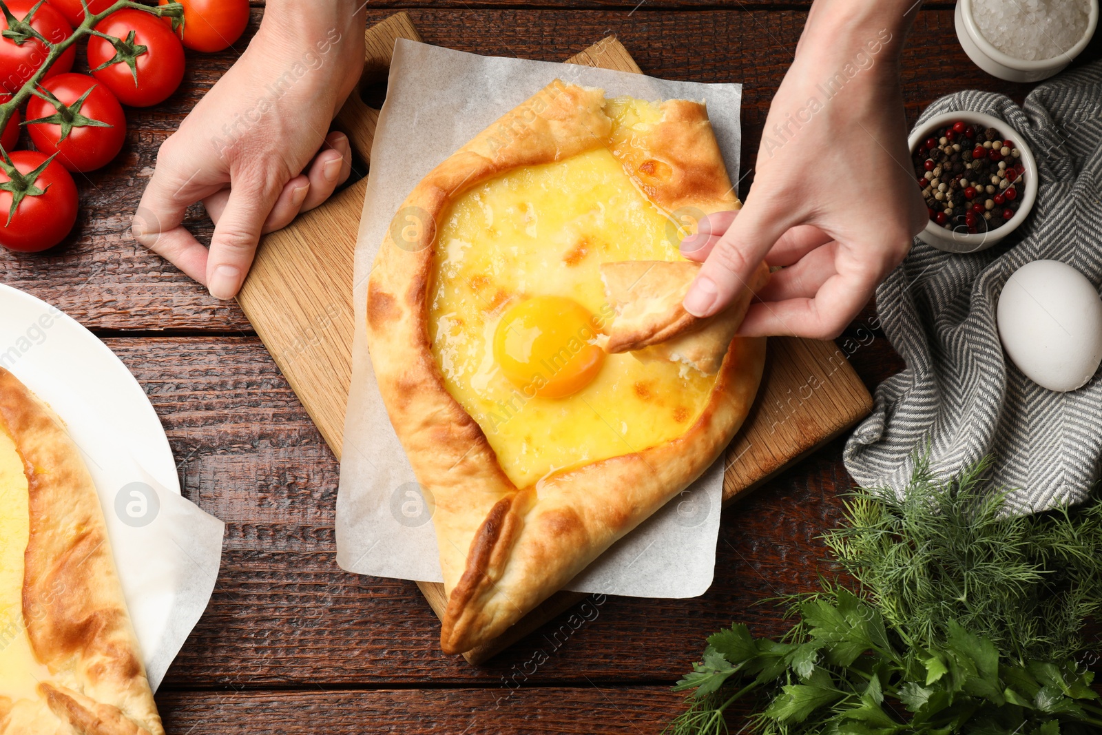 Woman eating delicious khachapuri at wooden table, top view Photo of Woman eating delicious khachapuri at wooden table, top view