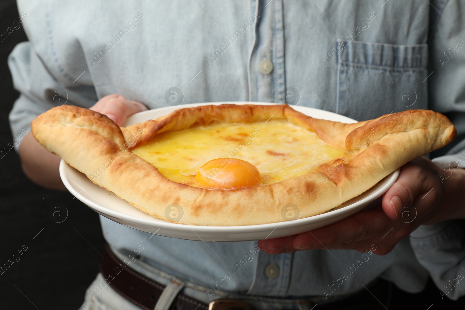 Woman with delicious khachapuri on black background, closeup Photo of Woman with delicious khachapuri on black background, closeup