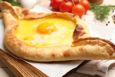 Photo of Tasty khachapuri with cheese and egg served on table, closeup