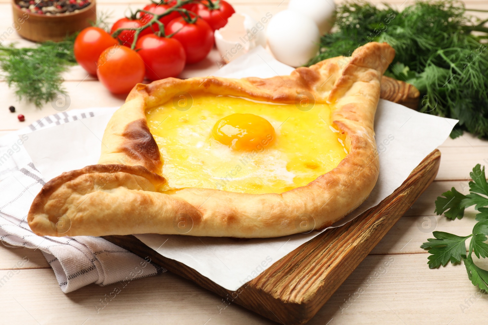 Tasty khachapuri with cheese and egg served on wooden table, closeup Photo of Tasty khachapuri with cheese and egg served on wooden table, closeup