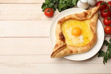 Photo of Tasty khachapuri with cheese and egg served on wooden table, flat lay. Space for text