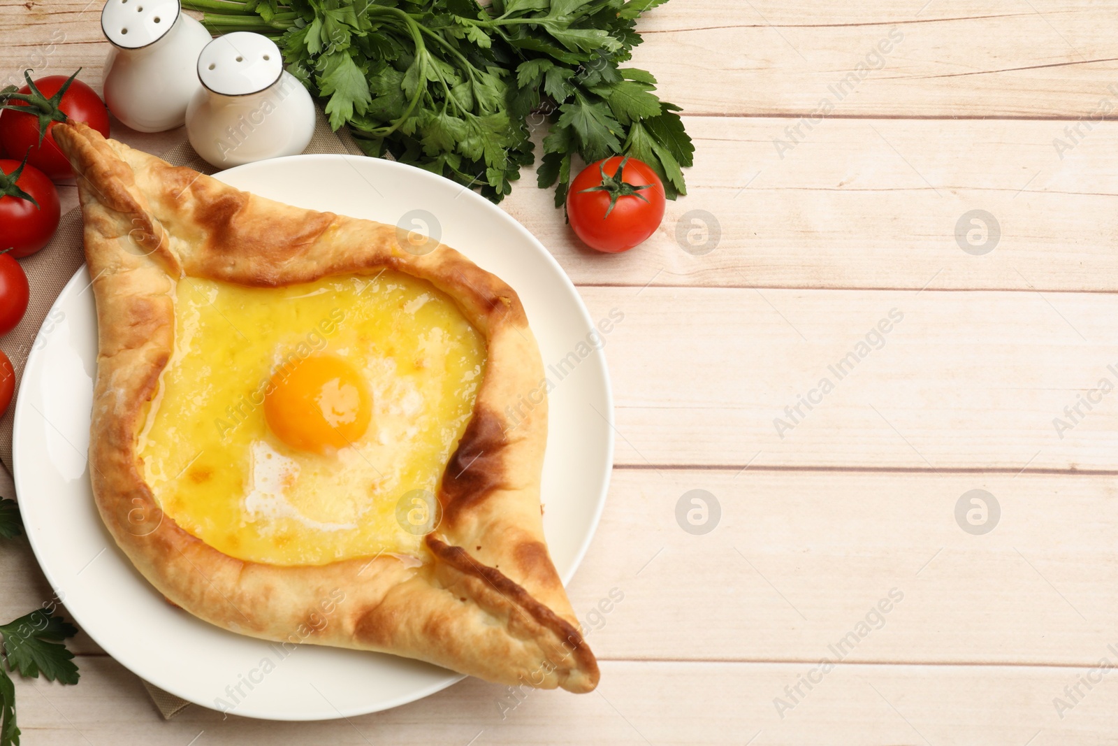 Tasty khachapuri with cheese and egg served on wooden table, flat lay. Space for text Photo of Tasty khachapuri with cheese and egg served on wooden table, flat lay. Space for text