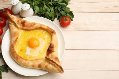 Photo of Tasty khachapuri with cheese and egg served on wooden table, flat lay. Space for text