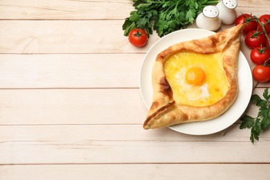 Photo of Tasty khachapuri with cheese and egg served on wooden table, flat lay. Space for text