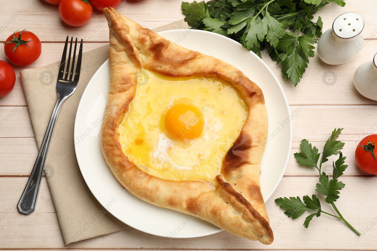 Tasty khachapuri with cheese and egg served on wooden table, flat lay Photo of Tasty khachapuri with cheese and egg served on wooden table, flat lay