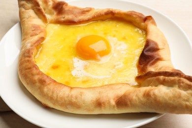 Photo of Tasty khachapuri with cheese and egg on table, closeup
