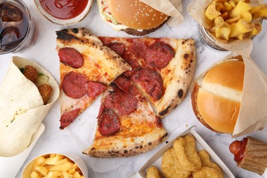 Photo of Different delicious fast food and soda drink on white marble table, flat lay
