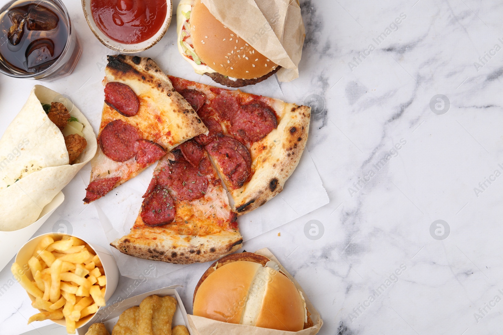 Different delicious fast food and soda drink on white marble table, flat lay Photo of Different delicious fast food and soda drink on white marble table, flat lay