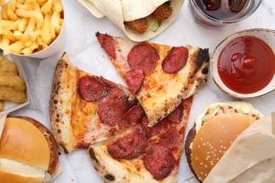 Photo of Different delicious fast food and soda drink on white marble table, flat lay