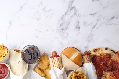 Photo of Different delicious fast food and soda drink on white marble table, flat lay. Space for text