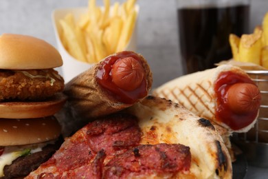 Photo of Different delicious fast food and soda drink on table, closeup