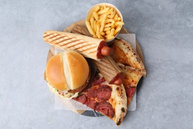 Photo of Different delicious fast food on grey table, top view